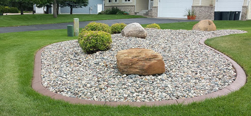 Large oblong shaped rock and shrub garden edged with a continuous concrete border by Unique Curbing
